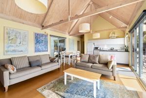 a living room with two couches and a table at Altair in Wye River