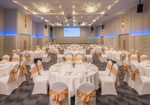 a conference room with white tables and chairs and a podium at Deevana Plaza Phuket - SHA Extra Plus in Patong Beach