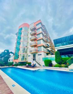 a hotel with a swimming pool in front of a building at Richjones Bed & Breakfast in Manila
