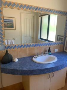 ein Badezimmer mit einem Waschbecken und einem großen Spiegel in der Unterkunft Rural Hideaway - Yallingup in Yallingup