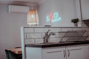 a kitchen with a sink and a sign on the wall at Spacieux Appartement de 3 Chambres downtown in Montreal