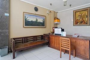 a reception desk in a restaurant with a picture on the wall at Gana Inn Legian in Legian