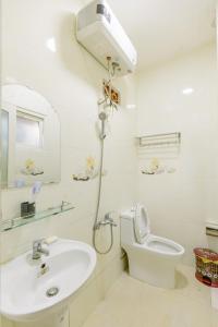 a white bathroom with a toilet and a sink at BACH TUNG Garden Village Đà Lạt in Xuan An