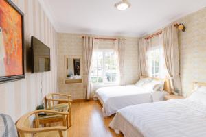 1 dormitorio con 2 camas y ventana en BACH TUNG Garden Village Đà Lạt en Xuan An
