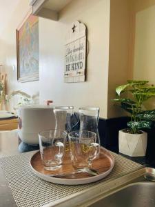 a tray with two glasses on a plate next to a sink at Richjones Bed & Breakfast in Manila