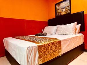 - une chambre dotée d'un lit avec un mur rouge et jaune dans l'établissement Smart Budget Hotel - Klang, à Klang