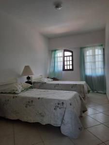 een slaapkamer met 2 bedden en een raam bij Casa do paiva in Cabo de Santo Agostinho