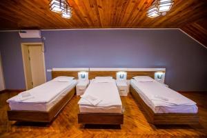 two beds in a room with a blue wall at ECO ART BOUTIQUE HOTEL in Tashkent