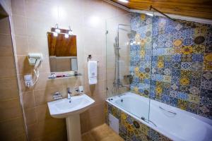 a bathroom with a tub and a sink and a shower at ECO ART BOUTIQUE HOTEL in Tashkent