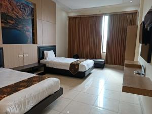 een hotelkamer met 2 bedden en een raam bij Shafira Hotel Yogyakarta in Ngabean