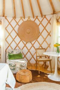 a room with a yurt with a chair and a table at Camposanto Glamping - The Peacock Yurt in Austin