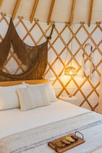 a bed in a yurt with a tray on it at Camposanto Glamping - The Peacock Yurt in Austin