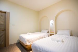 2 Betten in einem Zimmer mit weißer Bettwäsche in der Unterkunft PS23 Residence in Hat Yai