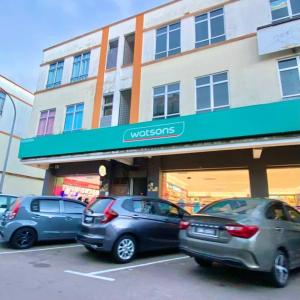 three cars parked in a parking lot in front of a building at 暖居Mersing Muji Cottage 0.3km Jeti Mersing Centre in Mersing