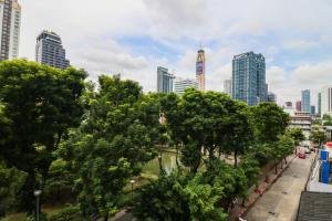 een stadsstraat met bomen en hoge gebouwen bij Royal View Resort - Rang Nam in Bangkok