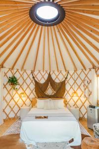 a bedroom with a bed in a yurt at Camposanto Glamping - The Peacock Yurt in Austin