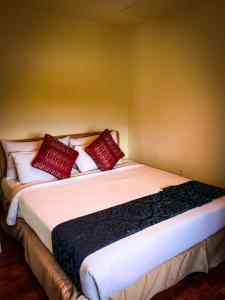een slaapkamer met een groot bed met rode kussens bij LANGKAWI LAGOON RESORT OCEAN SUITE in Pantai Cenang