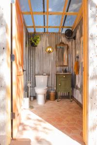 a bathroom with a toilet and a green cabinet at Camposanto Glamping - The Peacock Yurt in Austin