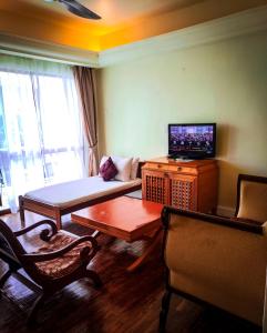 a living room with a couch and a tv at LANGKAWI LAGOON RESORT OCEAN SUITE in Pantai Cenang