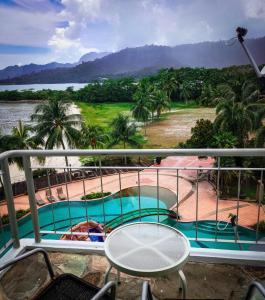 uma varanda com vista para uma piscina em LANGKAWI LAGOON RESORT OCEAN SUITE em Pantai Cenang