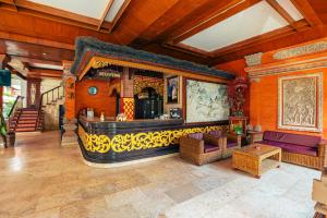 a living room with a bar in a house at Bali Summer Hotel by Amerta in Kuta