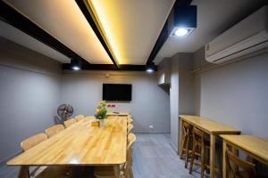 a conference room with wooden tables and chairs and a flat screen tv at PS23 Residence in Hat Yai