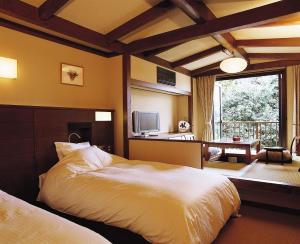 a bedroom with two beds and a large window at Kasuga Hotel in Nara