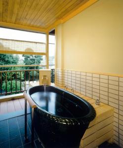 a large bath tub in a room with a window at Kasuga Hotel in Nara