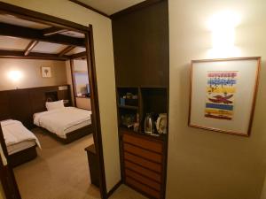 a room with a bedroom with a bed and a mirror at Kasuga Hotel in Nara