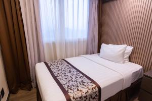 a bed in a room with a window and a pillow at Xenia Hotel Clark in Clark