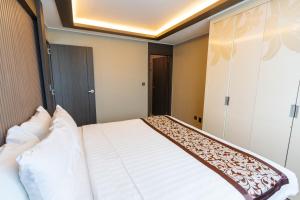 a bedroom with a large bed with white pillows at Xenia Hotel Clark in Clark