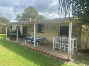 a house with a table and chairs on a patio at The Red Piranha Rainbow Beach in Rainbow Beach