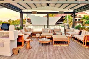 un patio con sofás, mesas y TV en Brand New Luxury Private Pool Villa Amber - 5 mins walk to #Sapphire Beach, en East End