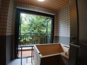 a bathroom with a tub and a large window at Kasuga Hotel in Nara