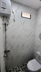une salle de bain blanche avec toilettes et fenêtre dans l'établissement CMI Homestay, à Tlekung 10 autres photos