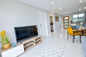 a living room with a large flat screen tv at Newly Built Guest House Walk to Lake in Toukley