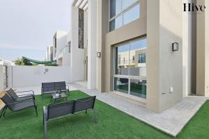 a building with benches and a green lawn at Ultra Modern 4 Bedroom Villa in Arabian Ranches 2 in Dubai
