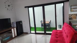 a living room with a red couch and a table at CMI Homestay in Tlekung