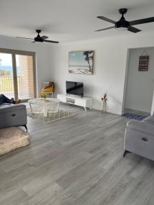 a living room with white walls and wood floors at Oceanview in Woorim
