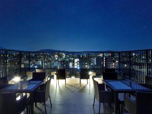 a rooftop deck with tables and chairs at night at MIMARU KYOTO NIJO CASTLE  in Kyoto