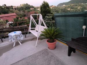 eine Veranda mit einer weißen Schaukel und einer Topfpflanze in der Unterkunft B&B Vicolo50 Salerno in Salerno