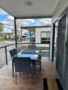 a patio with a table and chairs on a deck at Barwon River Holiday Park in Geelong
