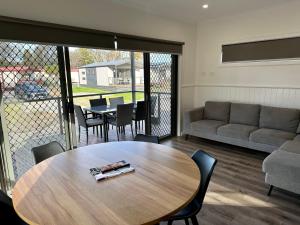 uma sala de estar com uma mesa e um sofá em Barwon River Holiday Park em Geelong