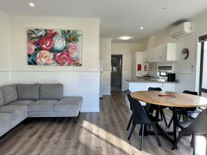 sala de estar con sofá, mesa y cocina en Barwon River Holiday Park, en Geelong