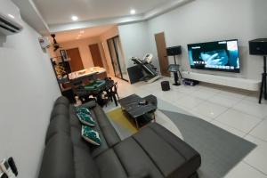 uma sala de estar com um sofá e uma televisão de ecrã plano em Happy Home BYSS Homestay em Puchong