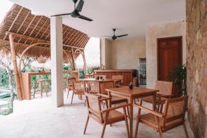 ein Restaurant mit Tischen und Stühlen und eine Terrasse in der Unterkunft Reset Lombok Hotel in Kuta Lombok