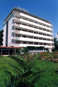 a large white building with a sign on it at Olymp Hotel in Sunny Beach