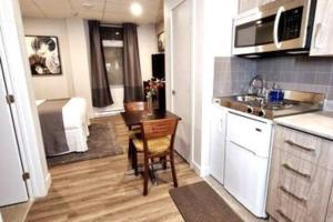 a kitchen with a table and a sink and a room at Cozy Sweet Studio #3. Ten min to D.T Ottawa in Gatineau