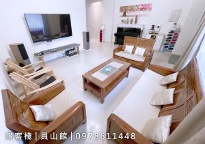 a living room with chairs and a table and a television at Yuanshan Dahu Homestay in Yuanshan