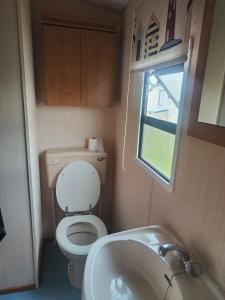 a small bathroom with a toilet and a sink at The hobbits in Dymchurch